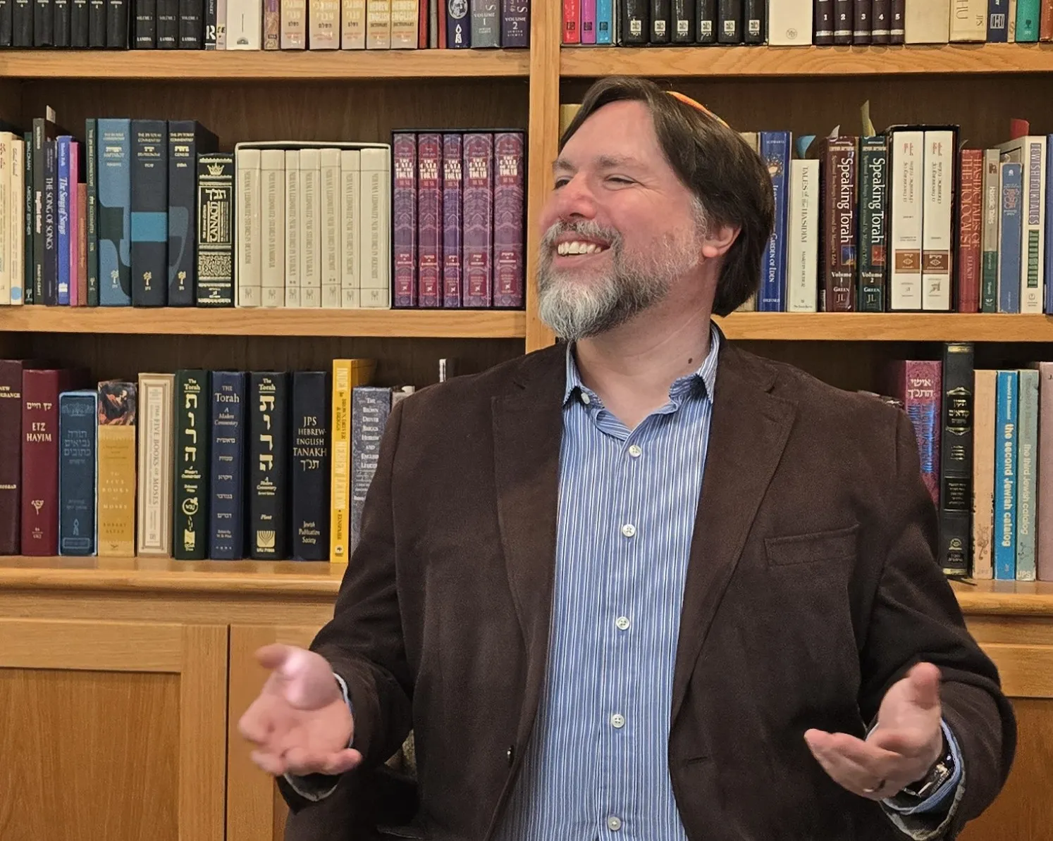 Rabbi Josh Breindel laughing in his book-lined office