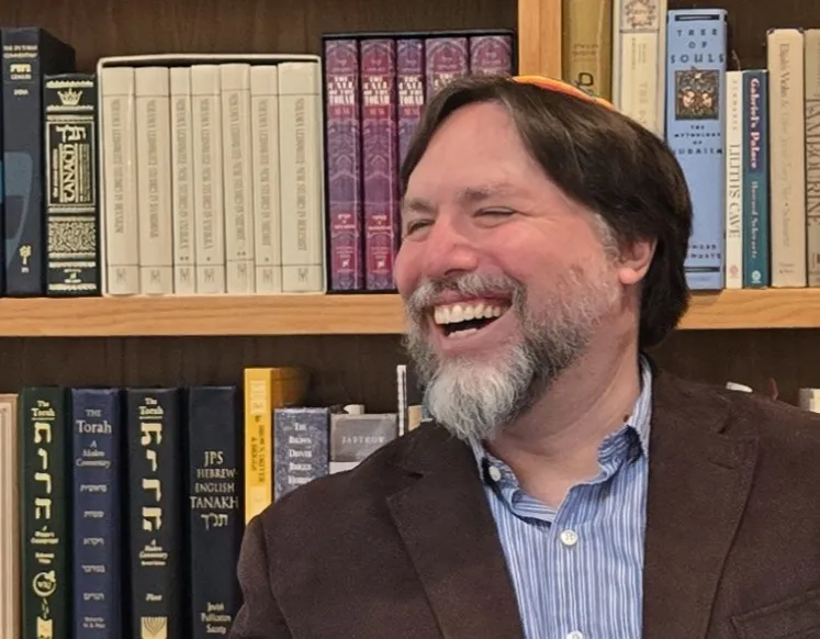 Josh smiling with books behind him